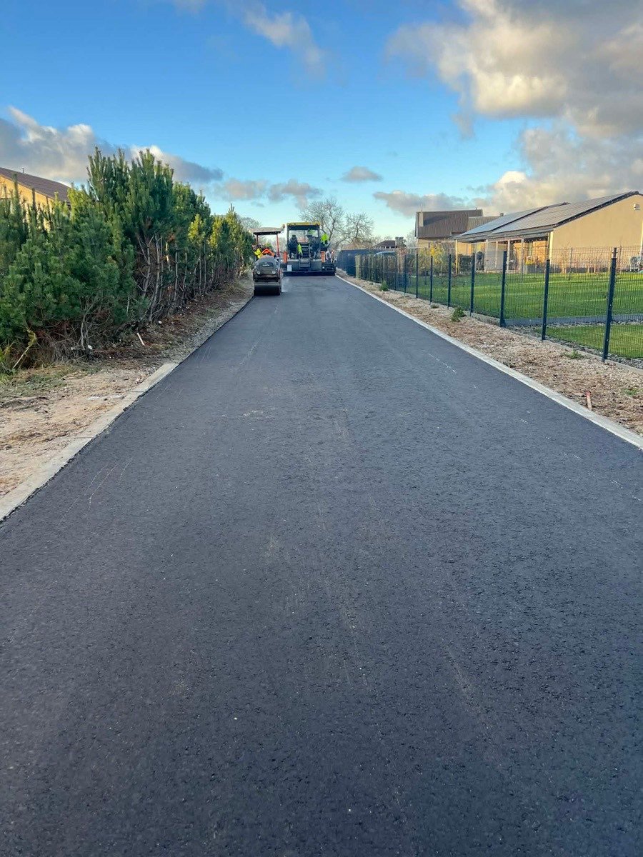 Šviežia asfalto danga kelyje su bordiūrais